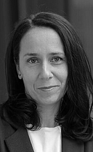 Vesna Kranjčec-Sang Eine Frau mit langen, dunklen Haaren lächelt leicht in die Kamera. Sie trägt ein schwarzes Blazerjackett und hat eine neutrale Umgebung im Hintergrund. Die Aufnahme ist in Schwarz-Weiß gehalten und vermittelt einen professionellen Eindruck.